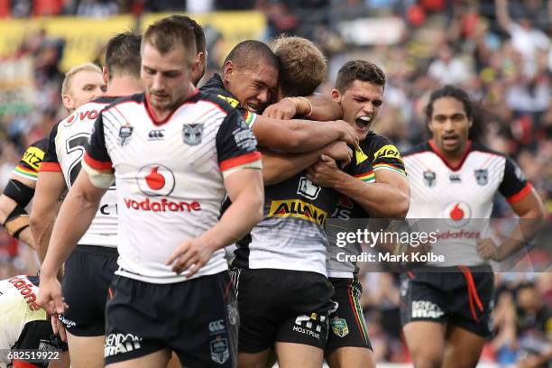 Leilani Latu and Nathan Cleary of the Panthers congratulate Matt Moylan of the Panthers celebrates with his team mates after scoring a try during the...