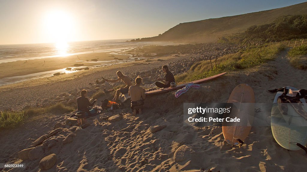 Friends relaxing on beach after surf