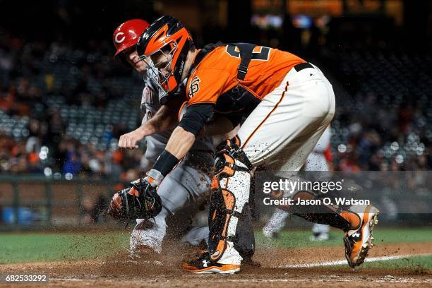Buster Posey of the San Francisco Giants tags out Scott Schebler of the Cincinnati Reds at home plate during the fourteenth inning at AT&T Park on...