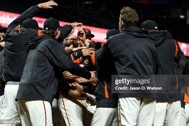 Buster Posey of the San Francisco Giants is congratulated by teammates after hitting a walk off home run against the Cincinnati Reds during the...