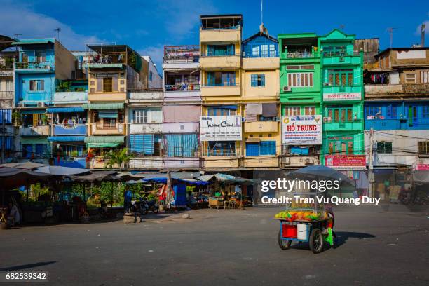 a salesman is pushing a car under the colorful street at an dong market. - ho chi minh city stockfoto's en -beelden