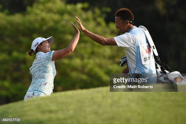 Ai Suzuki of Japan celebrates with her caddie on the 18th green after hitting out of the bunker for a birdie during the second round of the...