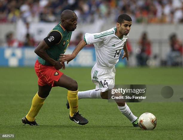 Abdulaziz al Khathran of Saudi Arabia looks to go past Geremi of Cameroon during the FIFA World Cup Finals 2002 Group E match played at the Saitama...