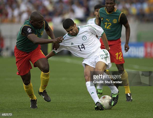Abdulaziz al Khathran of Saudi Arabia looks to go past Geremi of Cameroon during the FIFA World Cup Finals 2002 Group E match played at the Saitama...