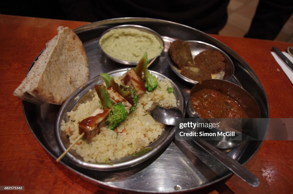 Vegetarian mezze platter with tofu and broccoli skewer with peanut sauce, couscous, pita bread, fava bean dip, falafel, and eggplant curry