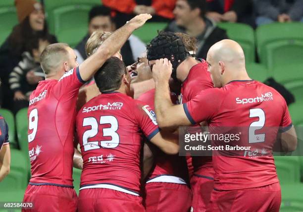 Samu Kerevi of the Reds is congratulated by his teammates after scoring the match-winning try during the round 12 Super Rugby match between the...
