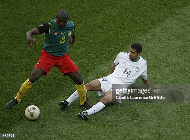 Abdulaziz al Khathran of Saudi Arabia tries to tackle Geremi of Cameroon during the FIFA World Cup Finals 2002 Group E match played at the Saitama...