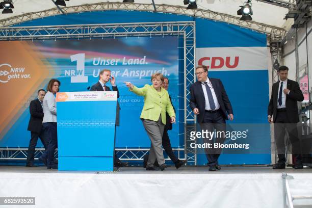 Angela Merkel, Germany's chancellor and Christian Democratic Union leader, center, gestures as she leaves the stage after speaking during a campaign...