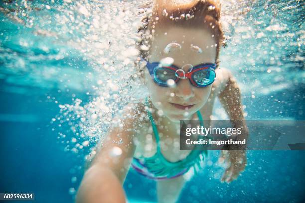 little girl swimming underwater. - swimming goggles stock pictures, royalty-free photos & images