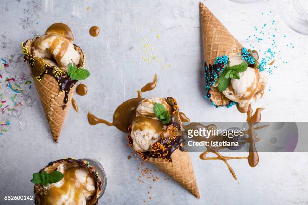 ice cream with caramel sauce in waffle cone - ice cream sundae stockfoto's en -beelden