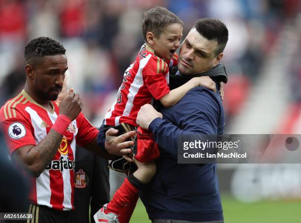Jermain Defoe of Sunderland hands Bradley Lowery back to his Dad Carl Lowery prior to the Premier League match between Sunderland and Swansea City at...