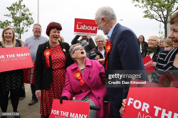 Labour Leader Jeremy Corbyn speaks with members of the public on the promenade as he is followed by activists waving placards on May 2017 in...