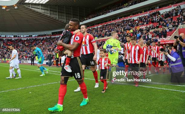 Jermain Defoe of Sunderland carries out mascot Bradley Lowery during the Premier League match between Sunderland and Swansea City at Stadium of Light...