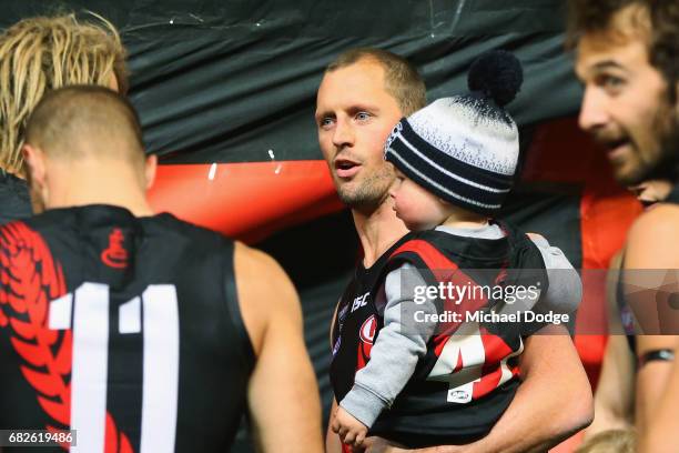 James Kelly of the Bombers walks out with his son for his 300th match during the round eight AFL match between the Essendon Bombers and the Geelong...