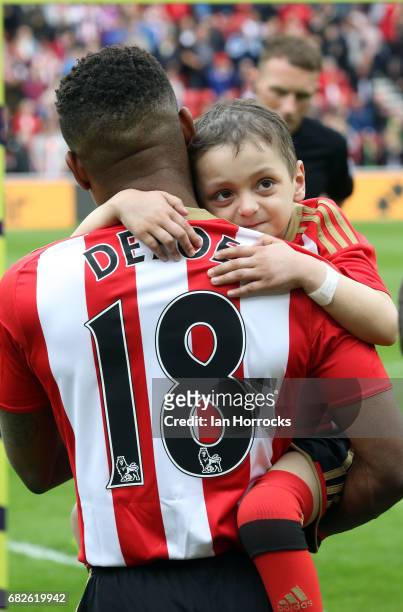 Jermain Defoe of Sunderland carries out mascot Bradley Lowery during the Premier League match between Sunderland and Swansea City at Stadium of Light...
