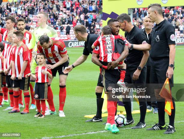 Jermain Defoe of Sunderland carries out mascot Bradley Lowery during the Premier League match between Sunderland and Swansea City at Stadium of Light...