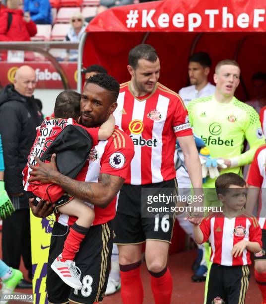 Sunderland's English striker Jermain Defoe holds Bradley Lowery , a five-year-old suffering from terminal cancer, as the players come out ahead of...
