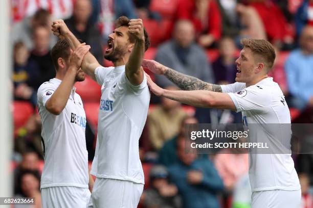 Swansea City's Spanish striker Fernando Llorente celebrates with Swansea City's Icelandic midfielder Gylfi Sigurdsson and Swansea City's English...