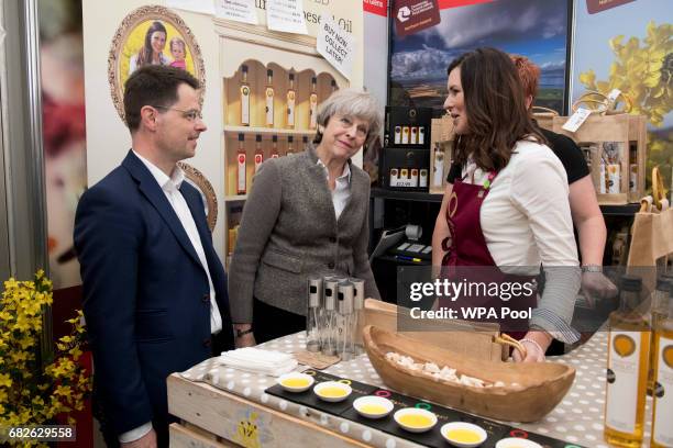 Britain's Northern Ireland Secretary James Brokenshire and British Prime Minister Theresa May speak with stall holders at the Balmoral Show during a...