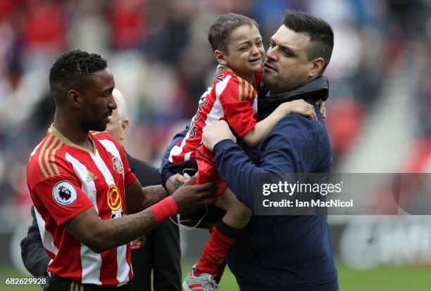 Jermain Defoe of Sunderland hands Bradley Lowery back to his Dad Carl Lowery prior to the Premier League match between Sunderland and Swansea City at...