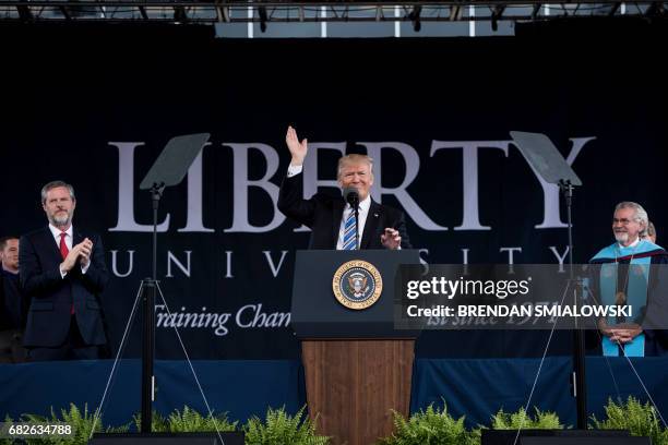 President of Liberty University Jerry Falwell and others clap as US President Donald Trump prepares to speak during Liberty University's commencement...