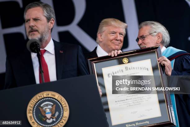 President of Liberty University Jerry Falwell speaks while US President Donald Trump is presented with an honorary doctorate during Liberty...