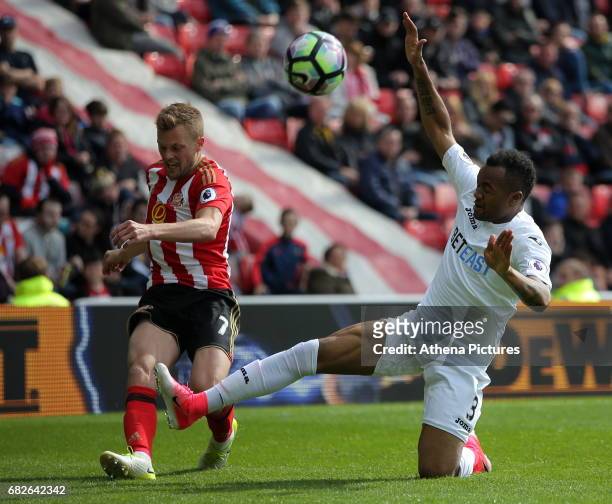 Seb Larsson of Sunderland has his shot blocked by Jordan Ayew of Swansea City during the Premier League match between Sunderland and Swansea City at...