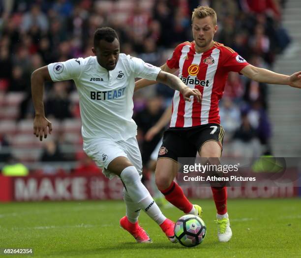 Jordan Ayew of Swansea City is chased by Seb Larsson of Sunderland during the Premier League match between Sunderland and Swansea City at the Stadium...