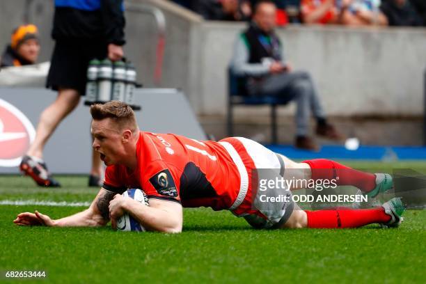 Saracens' English wing Chris Ashton dives over the try line to score the opening try during the rugby union European Champions Cup Final match...