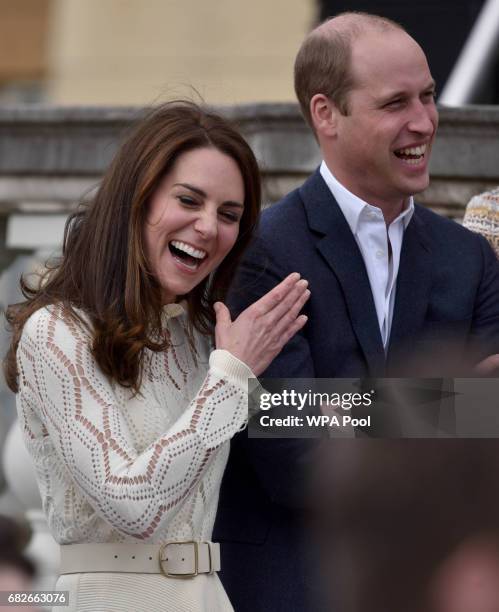 Catherine, Duchess of Cambridge and Prince William, Duke of Cambridge laugh as they host a tea party in the grounds of Buckingham Palace to honour...