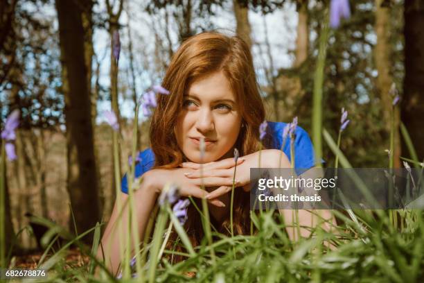 mooie jonge vrouw onder de bluebells - theasis stockfoto's en -beelden