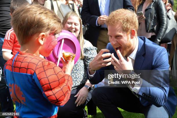 Prince Harry plays George Hinchliffe 3 as he hosts a tea party in the grounds of Buckingham Palace to honour the children of those who have died...