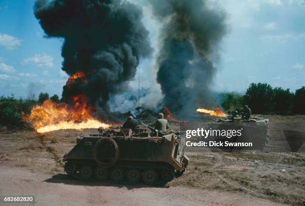 As part of Operation Cedar Falls, armored personnel carriers from the 1st squadron 4th Cavalry burn a field in the Iron Triangle village of Ben Suc,...