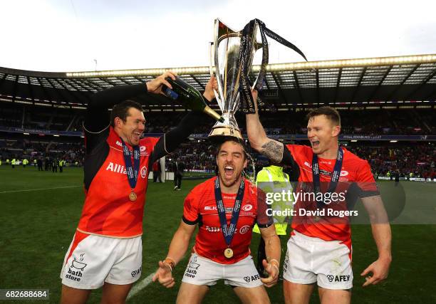 Alex Goode, Chris Wyles and Chris Ashton of Saracens celebrate with the trophy following his team's 28-17 victory during the European Rugby Champions...