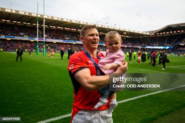 Saracens' English wing Chris Ashton holds his baby Ava, as he celebrates on the pitch after the rugby union European Champions Cup Final match...