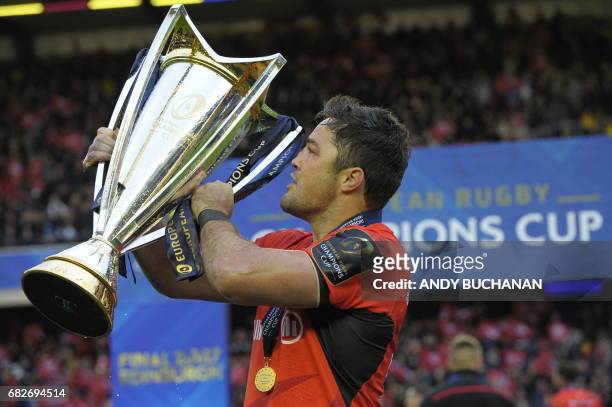 Saracens' South African-born English centre and captain Brad Barritt holds up the trophy as he celebrates their win on the pitch after the rugby...