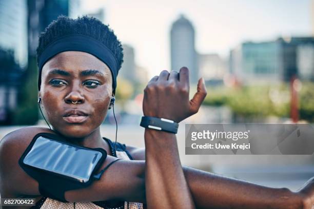 portrait of young female runner - armband stock-fotos und bilder