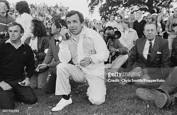 English golfer and non-playing captain, Tony Jacklin pictured talking in to a walkie talkie two way radio as he watches action for Team Europe to win...