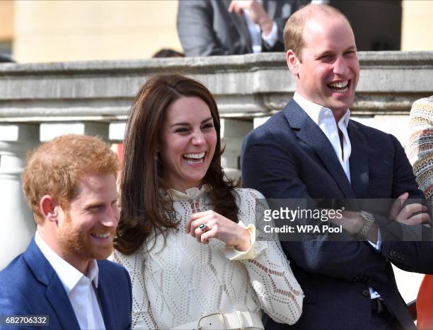 Prince Harry, Catherine, Duchess of Cambridge and Prince William, Duke of Cambridge laugh as they host a tea party in the grounds of Buckingham...