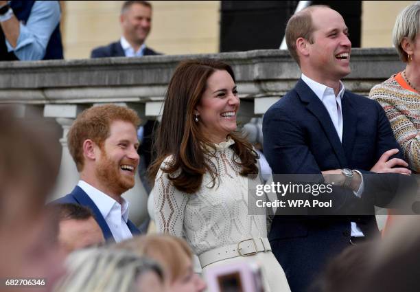 Prince Harry, Catherine, Duchess of Cambridge and Prince William, Duke of Cambridge laugh as they host a tea party in the grounds of Buckingham...