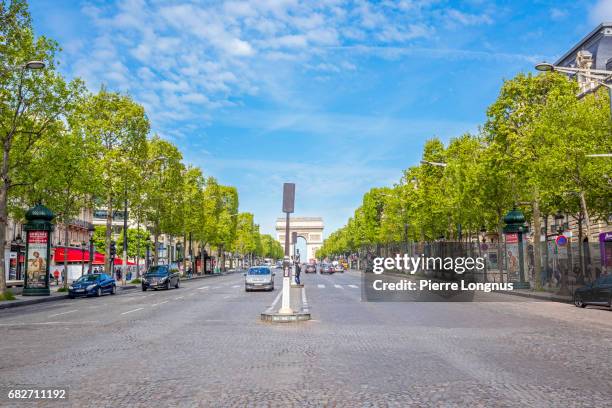 paris - france : springtime on the avenue des champs-élysées, with baby-leaves on the trees. - avenue champs élysées stock pictures, royalty-free photos & images