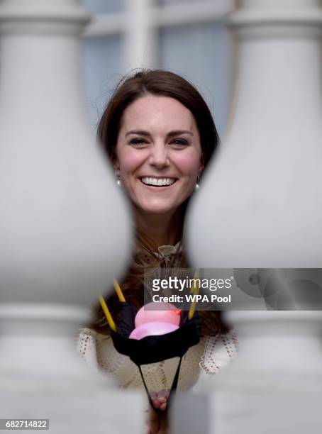 Catherine, Duchess of Cambridge is seen as she throws water bombs into the crowd off of the back balcony of Buckingham Palace as they host a tea...