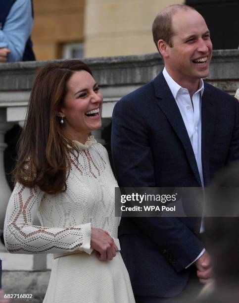 Catherine, Duchess of Cambridge and Prince William, Duke of Cambridge laugh as they host a tea party in the grounds of Buckingham Palace to honour...