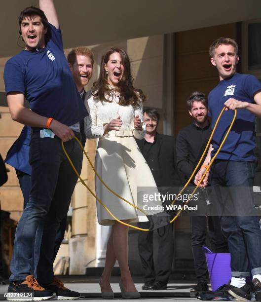 Prince Harry, Catherine, Duchess of Cambridge and Prince William, Duke of Cambridge laugh as they host a tea party in the grounds of Buckingham...