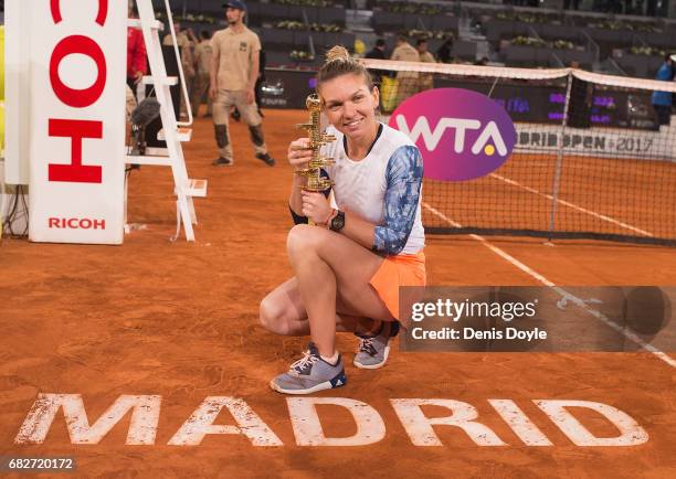 Simona Halep of Romania celebrates with the trophy after beating Kristina Mladenovic of France in their final match during day eight of the Mutua...