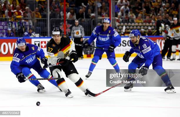 Alexander Egger of Italy challenges Patrick Reimer of Germany for the puck during the 2017 IIHF Ice Hockey World Championship game between Italy and...