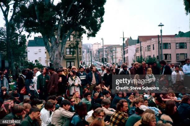 View of a large group of young men and women as they attend an unspecified event in a park in the Haight-Ashbury neighborhood, San Francisco,...