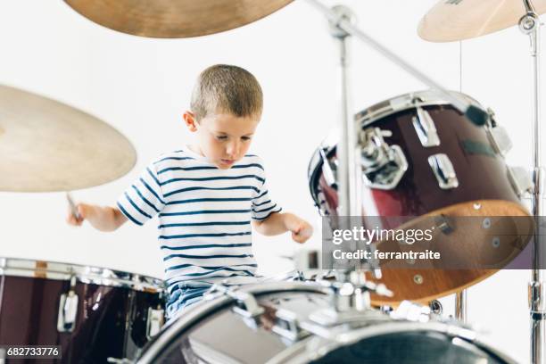 kleiner junge schlagzeug spielen - drums stock-fotos und bilder