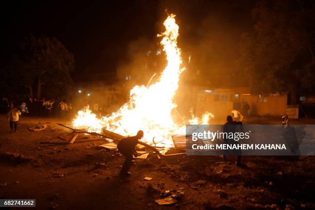 Ultra-Orthodox Jewish men light a giant oil fire in the Mea Shearim neighborhood of Jerusalem on May 13, 2017 during the celebration of Lag BaOmer....