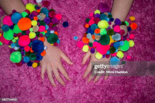 Multi colored pom pom bracelets on hands